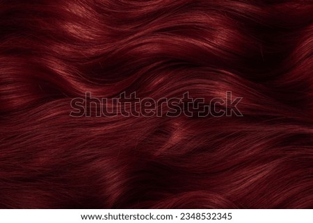 Dark red hair close-up as a background. Women's long brown hair. Beautifully styled wavy shiny curls. Coloring hair with bright shades. Hairdressing procedures, extension. Royalty-Free Stock Photo #2348532345