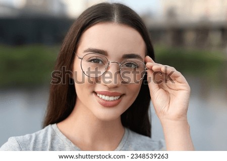 Portrait of beautiful woman in glasses outdoors. Attractive lady smiling and looking into camera Royalty-Free Stock Photo #2348539263