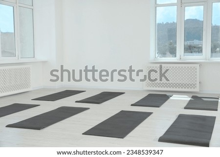 Spacious yoga studio with exercise mats and big windows