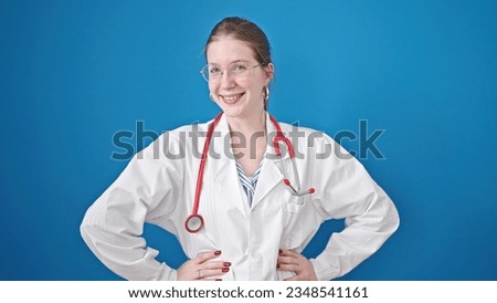 Young blonde woman doctor smiling confident saying yes with head over isolated blue background