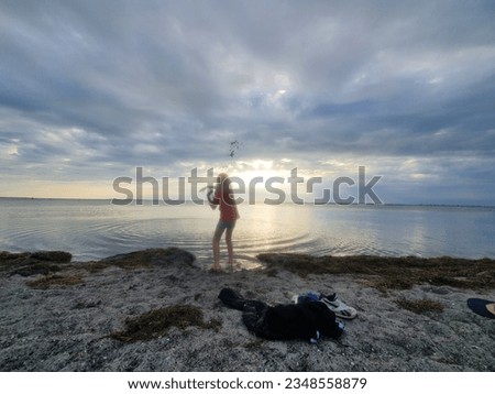 Sunset at sea with cloudy sky and young boy