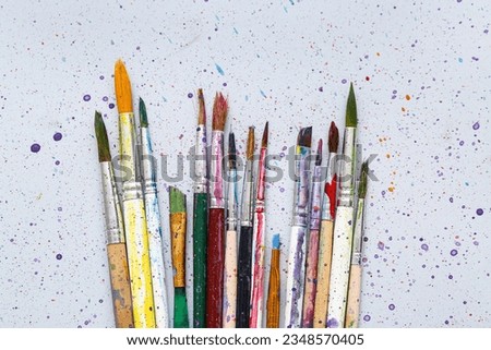 Artist's brushes with paints on grey background