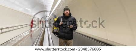 Panoramic photo of a male deliveryman in a subway crossing