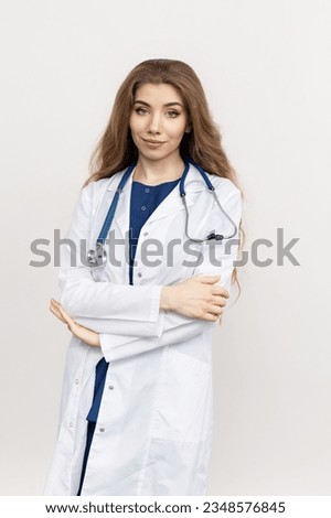 Classic portrait of a young female doctor on a white background. Attractive appearance, friendly medical staff