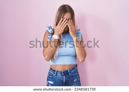 Young blonde woman standing over pink background rubbing eyes for fatigue and headache, sleepy and tired expression. vision problem 
