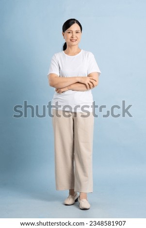 full body photo of an elderly woman posing on a blue background