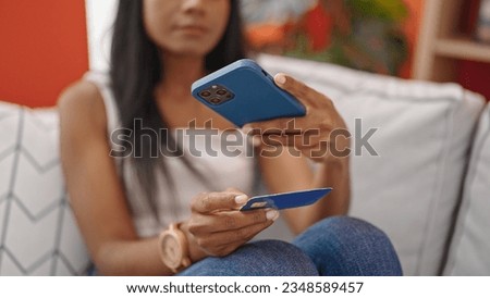 African american woman make photo to credit card sitting on sofa at home