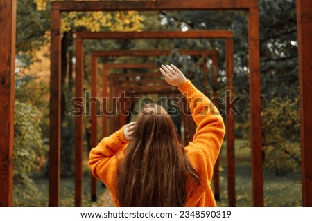 Autumn wellbeing, ways to protect your mental health during darker months. Mental wellness in the fall. Back view of beautiful redhead woman with perspective fall autumn nature park background. Royalty-Free Stock Photo #2348590319