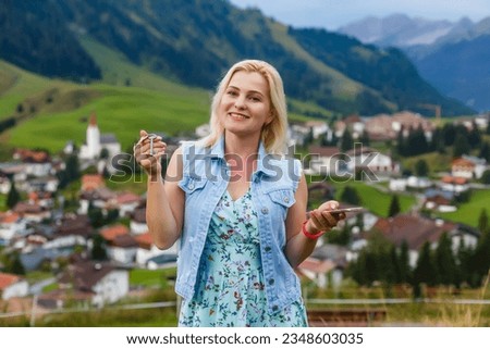 woman holding keys and smartphone