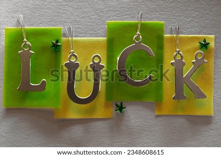 Metallic letters hanging next to each other creating positive word - LUCK