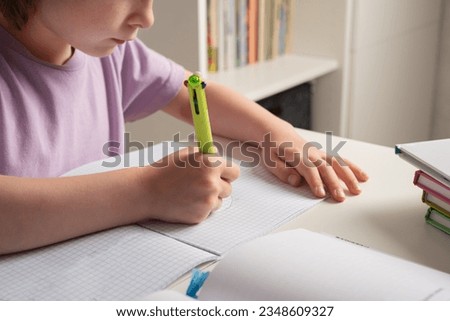 Close-up of children's hands. Left-hander writes in a notebook on the table. Left handed child. International Left Handers Awareness Day Royalty-Free Stock Photo #2348609327