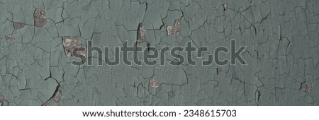 Peeling paint on the wall. Panorama of a concrete wall with old cracked flaking paint. Weathered rough painted surface with patterns of cracks and peeling. Grunge texture for wide panoramic background Royalty-Free Stock Photo #2348615703
