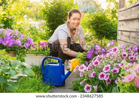 Gardening and agriculture concept. Young woman farm worker gardening flowers in garden. Gardener planting flowers for bouquet. Summer gardening work. Girl gardening at home in backyard
