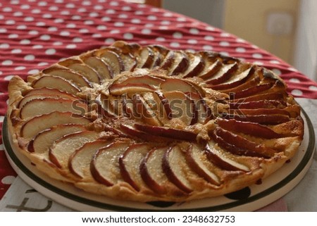 Tart with thin slices of apples lit by the razing light of a window. Apple pie Royalty-Free Stock Photo #2348632753