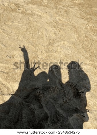 Sunlit Beach Bonding: Aerial View of Friends Enjoying Leisure Time Together on the Shore. Aerial view of friends bonding on sunny beach, with shadows and ocean.