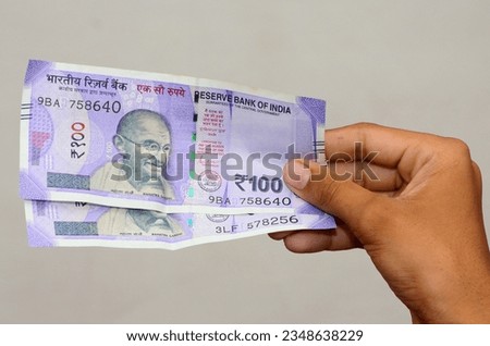 Hand holding Indian Currency 100 rupee note Royalty-Free Stock Photo #2348638229