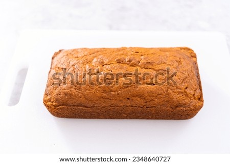 Sliced homemade pumpkin bread on a white cutting board. Royalty-Free Stock Photo #2348640727