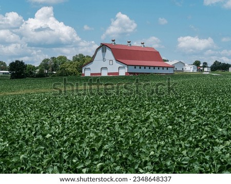 Midsummer agricultural field bursting with greens with stylish red roof barn in Missouri Royalty-Free Stock Photo #2348648337