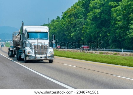Horizontal shot of a white tanker truck on an interstate highway with copy space. Royalty-Free Stock Photo #2348741581