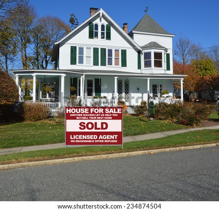 Real Estate sold (another success let us help you buy sell your next home) side of suburban gable front Victorian style house in residential neighborhood clear blue sky USA