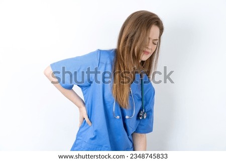 Young caucasian doctor woman wearing medical uniform Suffering of backache, touching back with hand, muscular pain