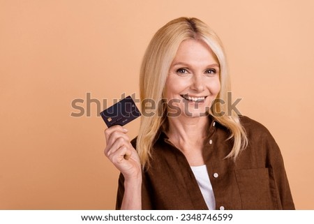 Photo advertisement of middle age lady hold plastic black ecard web shopping online proposition payment isolated on beige color background