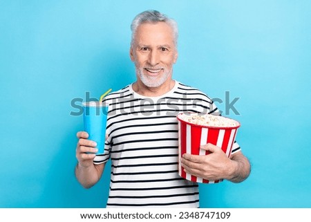 Photo of excited cheerful man wear trendy clothes hold popcorn soda enjoy free time weekend isolated on blue color background