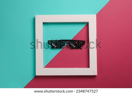 8 bit pixel sunglasse in white frame on pink blue background. Creative layout. Minimalism