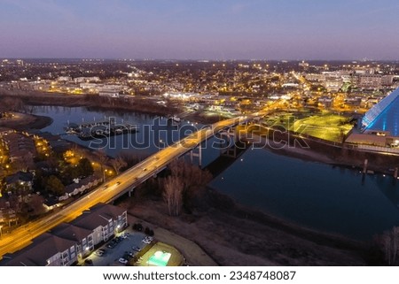 aerial shot of Wolf River Harbor at sunset with cars and trucks driving on the street, lights and the waters of the Mississippi River at Greenbelt Park on Mud Island in Memphis Tennessee USA
