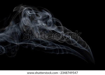 White clouds of smoke with copy space on black background. Halloween, colour, movement and smoke concept.