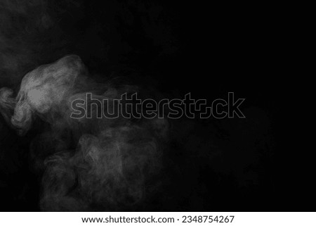White clouds of smoke with copy space on black background. Halloween, colour, movement and smoke concept.