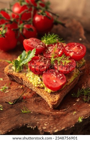 Deliciously topped toast with creamy guacamole and vibrant sliced cherry tomatoes for a refreshing bite. Royalty-Free Stock Photo #2348756901