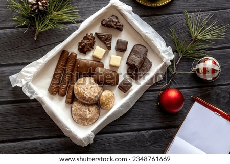 Christmas decor, sweets on wooden table. blank notebook sheet for plan for new year in cozy setting.