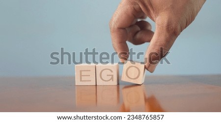 wooden alphabet blocks reading - Ego - balanced in the palm of his hand in a conceptual image. Royalty-Free Stock Photo #2348765857