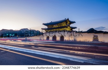 Gyeongbokgung palace in Seoul City, South Korea during a blue hour with light trails of passing traffic visible in foreground. Korean text translated to english says Gwanghwamun, whis is name of gate. Royalty-Free Stock Photo #2348774639