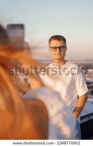 young man with glasses is photographed on mobile phone