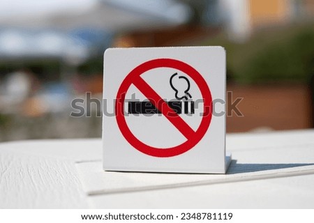"No smoking" sign. Smoking is prohibited in public places. Forbidding banner on the table against the backdrop of a public place. Attention, do not smoke.