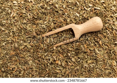 Wooden spoon and dried savory (satureja). Close-up.