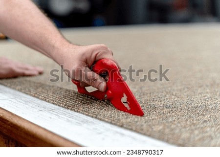 Cutting carpet with a knife Royalty-Free Stock Photo #2348790317