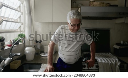 Worried senior man standing in home kitchen ruminating thoughts and past memories feeling regret and remorse Royalty-Free Stock Photo #2348804393