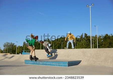 Teenager friends having recreation time in urban skate park