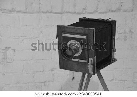 Old retro vintage large wooden photo camera black and white picture film brick white background