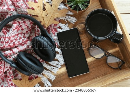 A phone with headphones for listening to audiobook, music or podcast - blank screen mock up