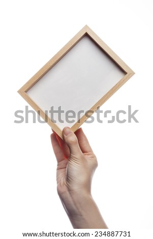A female(woman) hand hold a empty(blank) wood photo(picture) frame isolated white at the studio. 