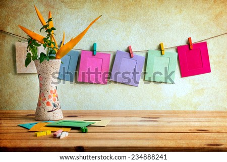 paper photo frame on clothesline over grunge background