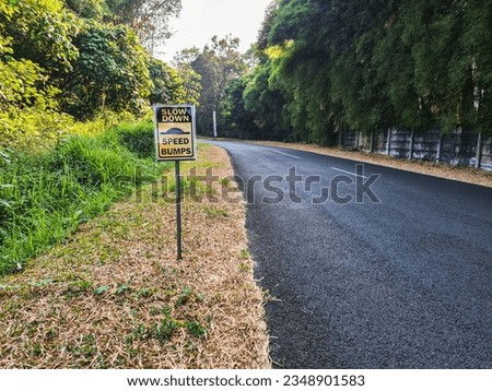 Road sign warning: Slow Down Speed Bumps on a quiet street