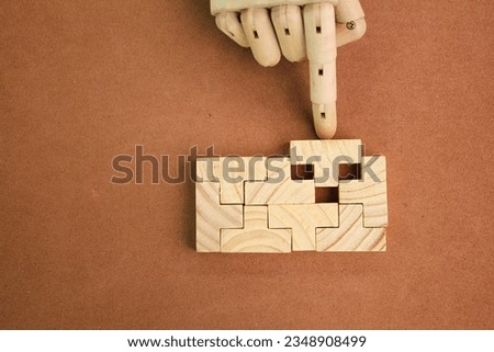 The wooden puzzle is arranged and completed. Concept of complex and smart logical thinking. Slightly defocused and close up shot. Copy space. Royalty-Free Stock Photo #2348908499