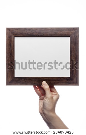 A female(woman) hand hold a empty(blank) wood frame isolated white at the studio.