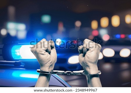Police car and man in handcuffs Royalty-Free Stock Photo #2348949967