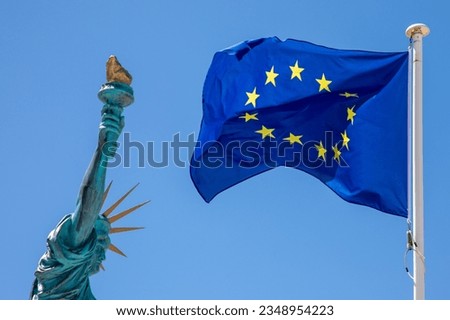Statue of Liberty with European Union EU Flag yellow stars Waving in mat on blue sky background